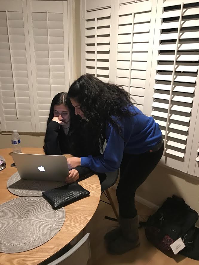 Older sibling Mary Mikaili (right) helps her younger sister Marina Mikaili (left) with an assignment. Mary made sure Marina understood what she was teaching, so she could do well. (Courtesy of Mary Mikaili)