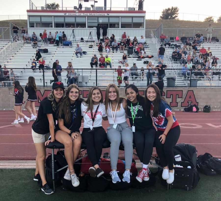 Student athletic trainers prepare for a football game. They helped players fill water bottles and Gatorade and assisted them with injuries. 
