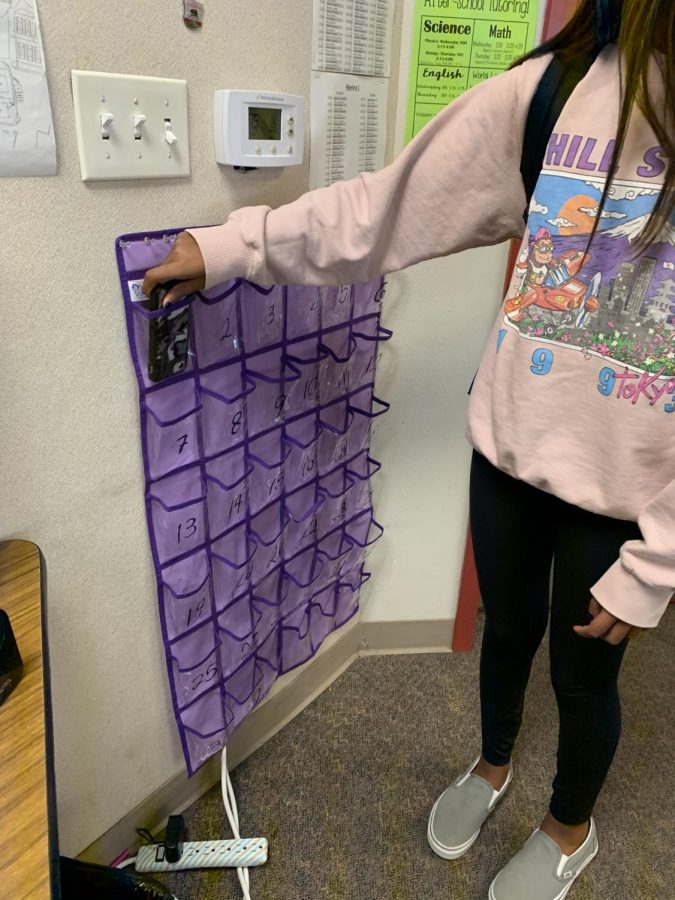 Freshman Avani Desai is putting her phone into the phone jail in Phoebe Roddewigs classroom before class starts.
