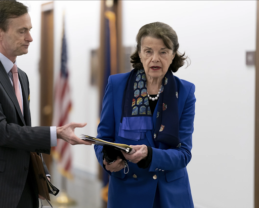 U.S. Senator Diane Feinstein hands a file of papers to a political intern on Capitol Hill. After years of declining health, Feinstein announced she would not run in 2024 and prominent CA Democrats pounced on the opportunity. 