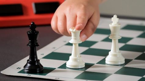 The Dark King is in checkmate because of the Light Queen attacking and blocking the escape of the Dark King with the Light King backing her up. Chess has been a game played throughout centuries and continues to be played today.