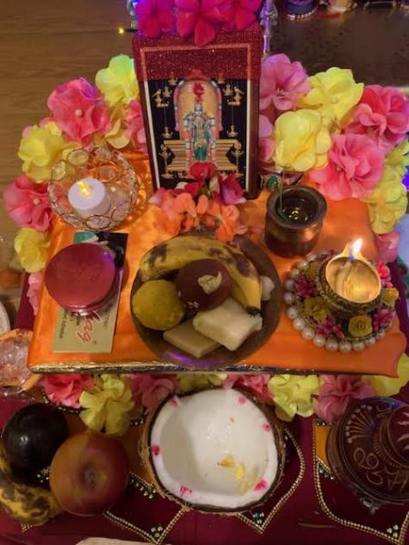 A Diwali altar/ puja setup from Roma Singh, commonly created for worship during the festival. The setup typically has an idol or picture of a deity at the center, offerings (prasad) such as fruits and sweets, a diya (oil lamp), flowers, and other decorative items such as vibrant fabrics and candles.  This setup is used for Lakshmi Puja or other prayers performed to seek blessings of prosperity, health, and happiness during Diwali.